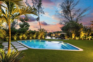 A swimming pool with a surrounding lawn and tropical vegetation. - Villa Lake (Miami)