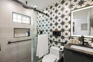Un baño moderno con ducha, inodoro y lavamanos.