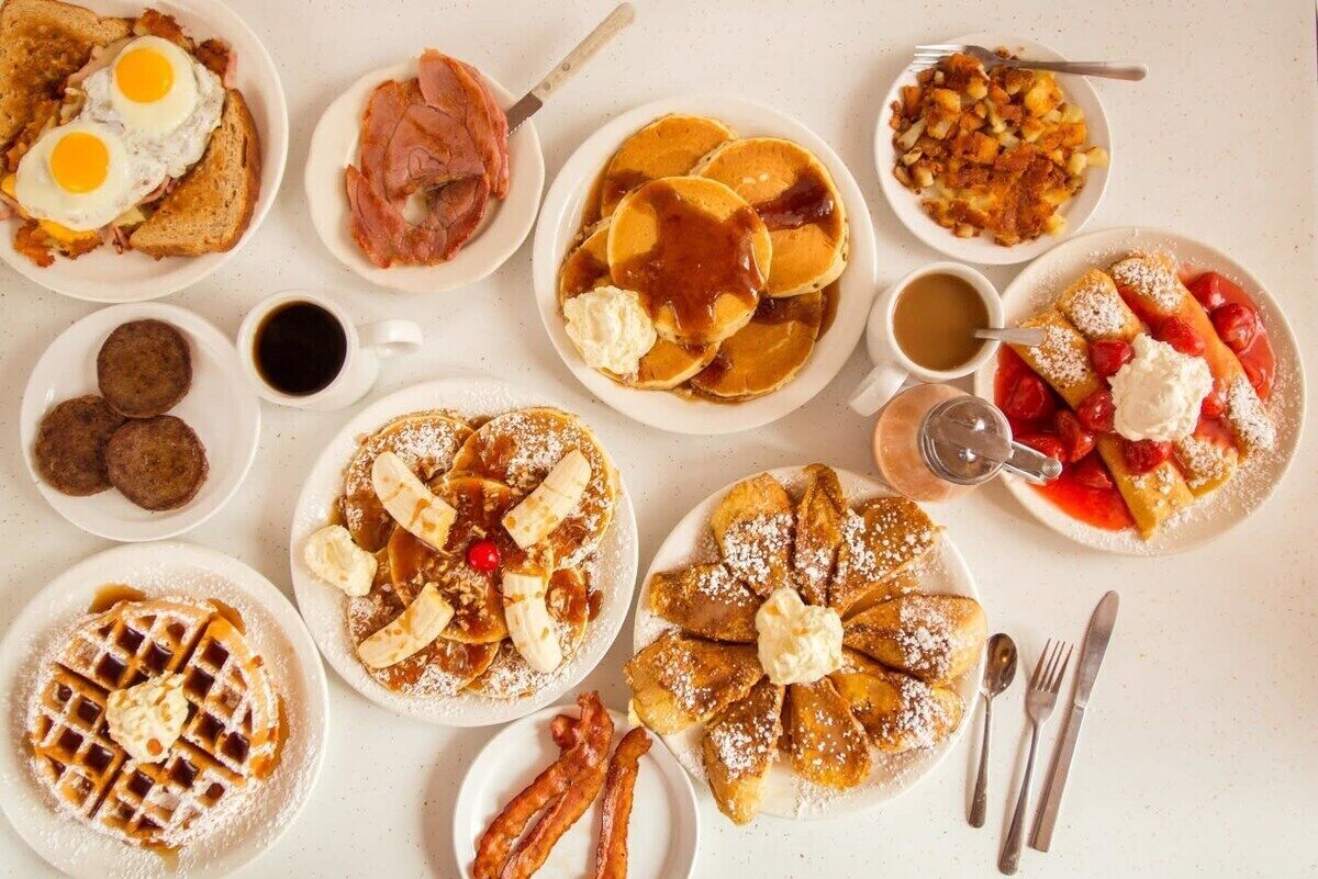 Verschiedene Frühstücksgerichte, darunter Waffeln, Pfannkuchen und Gebäck.