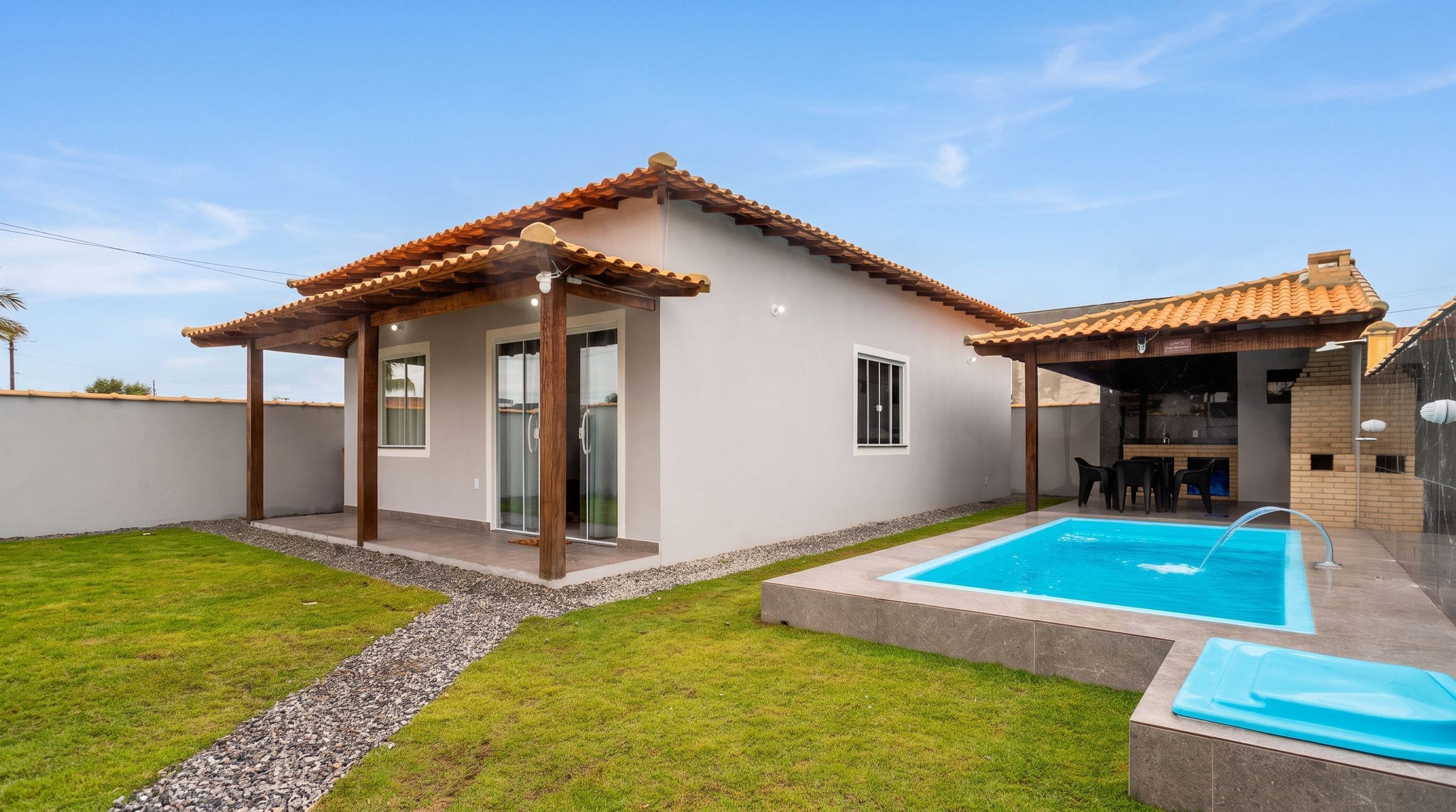 A residential property with a swimming pool, a covered patio, and a well-maintained lawn.