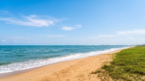 Une plage avec un ciel dégagé et une mer calme.