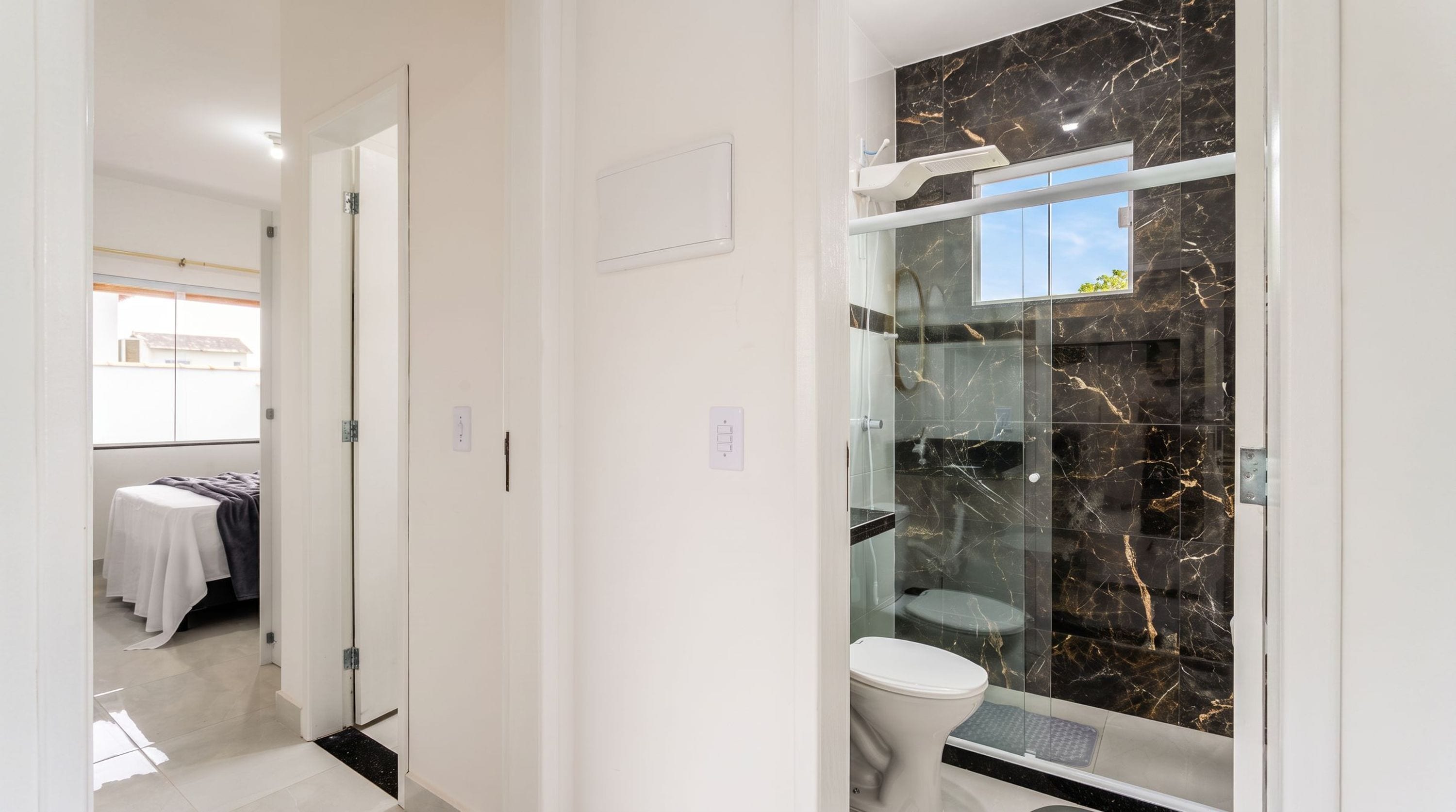 A modern bathroom with a glass shower enclosure, a toilet, and a sink.