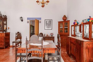 A dining area with a wooden table, chairs, and a chandelier. - Country House 'Casa Da Quinta' with Shared Pool and Shared Garden (Évora)
