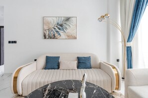 Ein modernes Wohnzimmer mit einer Couch, einem Couchtisch und einer Stehlampe.