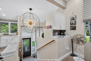 A modern kitchen with a unique chandelier, a coffee maker, and a fan. - Luxury Lake Geneva 2BR/2BA retreat fully renovated sleeps up to 6 near lake Como (Lake Geneva)