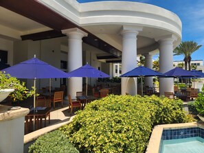 A poolside area with outdoor seating and umbrellas. - Spacious Dawn Beach 3-bedroom condo in delightful Upper Prince's Quarter (Upper Prince's Quarter)