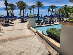 A poolside area with lounge chairs, palm trees, and a clear sky. - Spacious Dawn Beach 3-bedroom condo in delightful Upper Prince's Quarter (Upper Prince's Quarter)