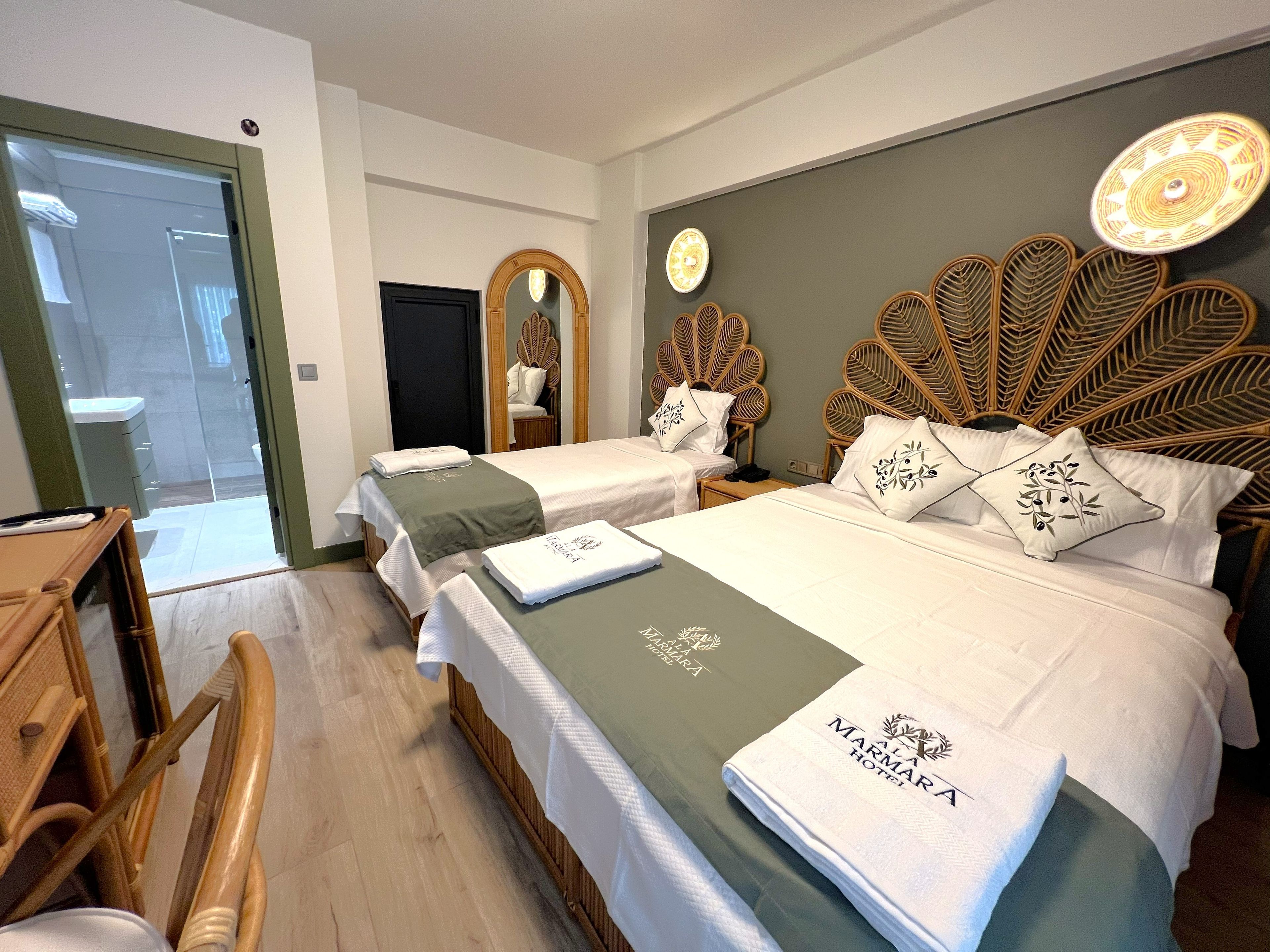 Habitación de hotel con dos camas, cabecero de madera, un espejo, un reloj y una mesita.