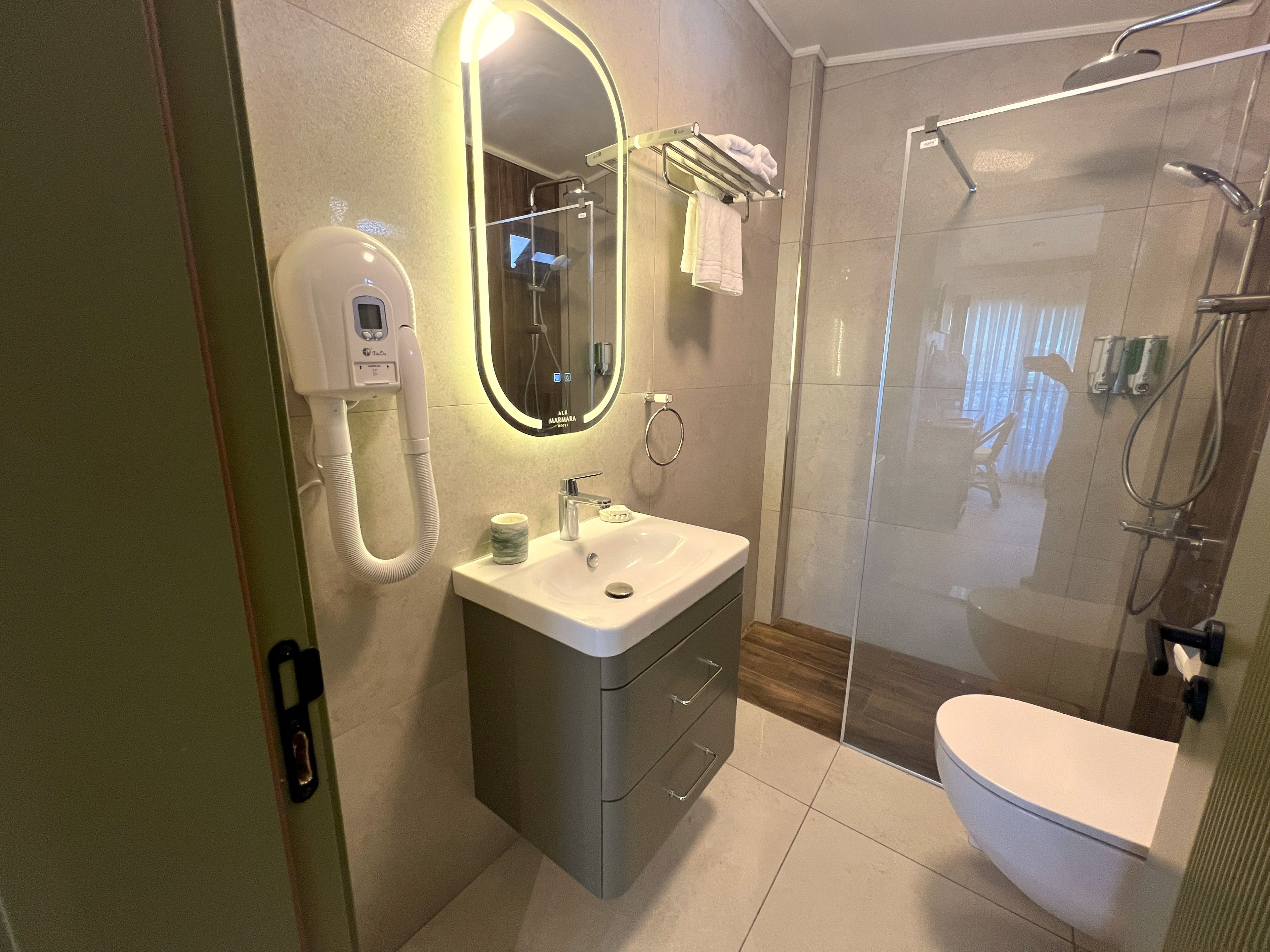 Une salle de bain moderne dotée d’une douche à parois de verre, d’un lavabo encastré et d’un meuble-lavabo avec des tiroirs.