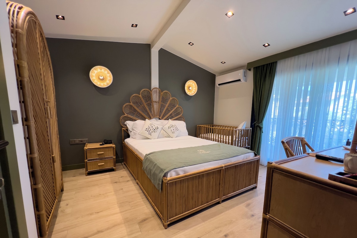 A modern bedroom with a wooden bed, bedside tables, a desk, and a large window with curtains.