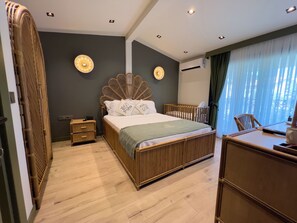 Un dormitorio moderno con cama de madera, mesitas de noche, un escritorio y un ventanal con cortinas.