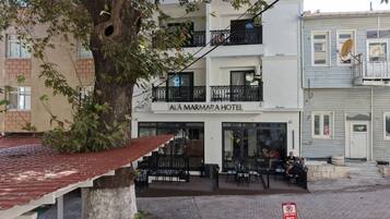 Un hotel con un letrero que dice 'AI AMARAHOTEL' y asientos al aire libre.