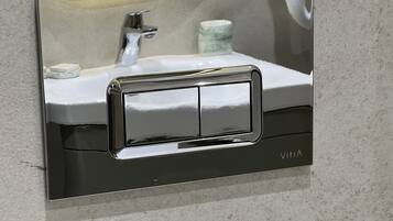 Un lavabo con grifo de cromo y dispensador de jabón.