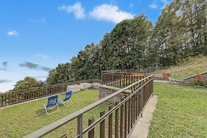 A grassy area with a wooden fence, a stone wall, and a view of a mountain. - Chalet 'Rosi' with Lake View Balcony, Terrace, BBQ, and Private Parking (Gravedona ed uniti)