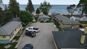 Una zona residenziale costiera con case, un vialetto sterrato e vista sul mare.