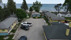 Et kystnære boligområde med huse, en grusindkørsel og havudsigt.