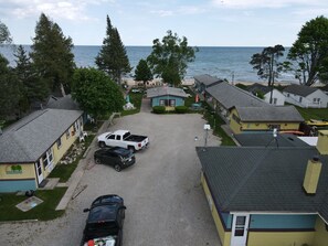 Una zona residenziale costiera con case, un vialetto sterrato e vista sul mare.