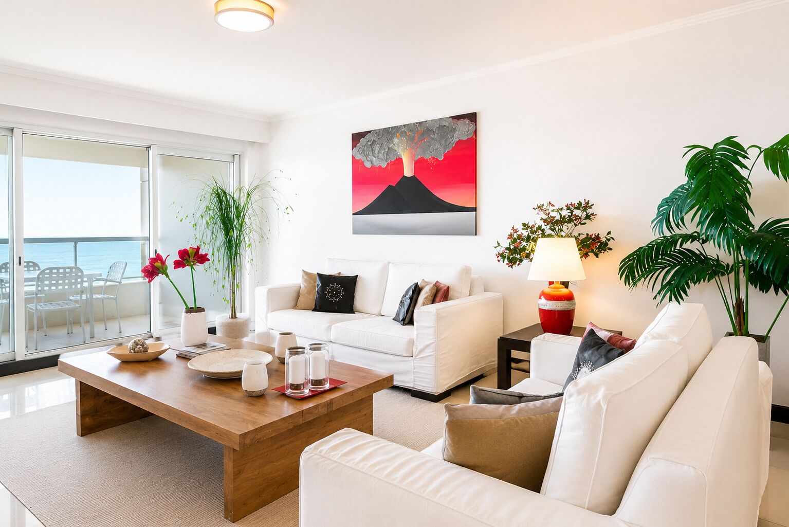 A modern living room with a white sofa, a wooden coffee table, and a painting of a volcano.