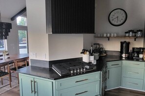 Una cocina moderna con estufa a gas, un reloj y varios electrodomésticos.