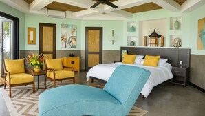 A hotel room with a bed, two chairs, a nightstand, a wall-mounted shelf, and a painting. - Vivara: Private House, PH & 5 Villas 180° Ocean View, Dominical CR-16 guest (Savegre de Aguirre, Puntarenas Province)