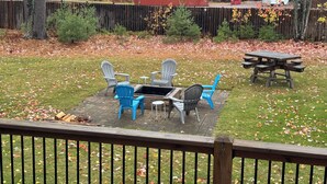 A backyard with a fire pit, outdoor furniture, and a picnic table. - Timberville - Hank (Gwinn)