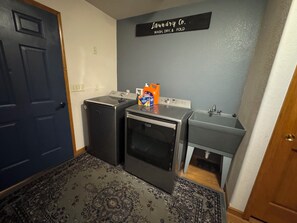A laundry room with a washing machine, dryer, and sink.