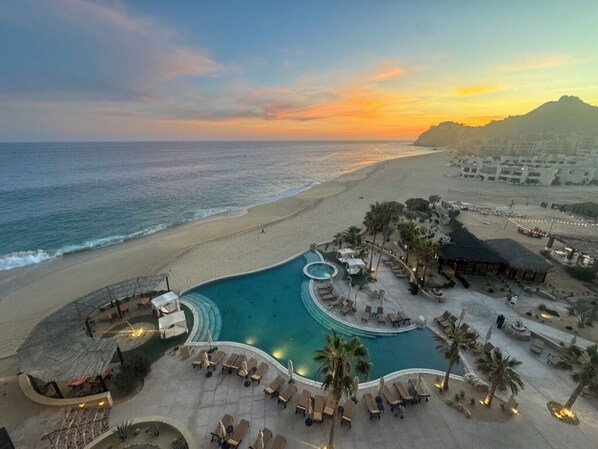 Um resort com piscina, áreas de lazer e vista para a praia.