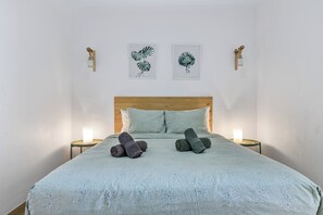 A bedroom with a bed, two wall-mounted lights, and two framed botanical prints. - Home2Book Las Canteras Beach & City Stay (Las Palmas de Gran Canaria)