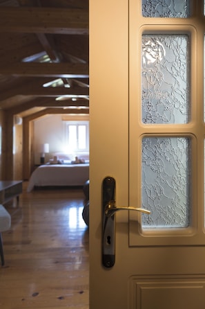 A door with frosted glass panels and a keyhole, leading to a room with wooden floors and a bed. - A neoclassical monument with Acropolis view in the Historic Center of Athens (Athina)