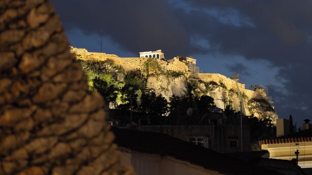 A historical building with classical architecture, including columns and a temple-like structure, situated on a hill with a stone wall in the foreground. - A neoclassical monument with Acropolis view in the Historic Center of Athens (Athina)