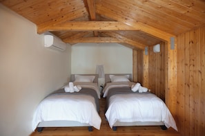 A room with two beds, wooden ceiling beams, and an air conditioning unit. - A neoclassical monument with Acropolis view in the Historic Center of Athens (Athina)