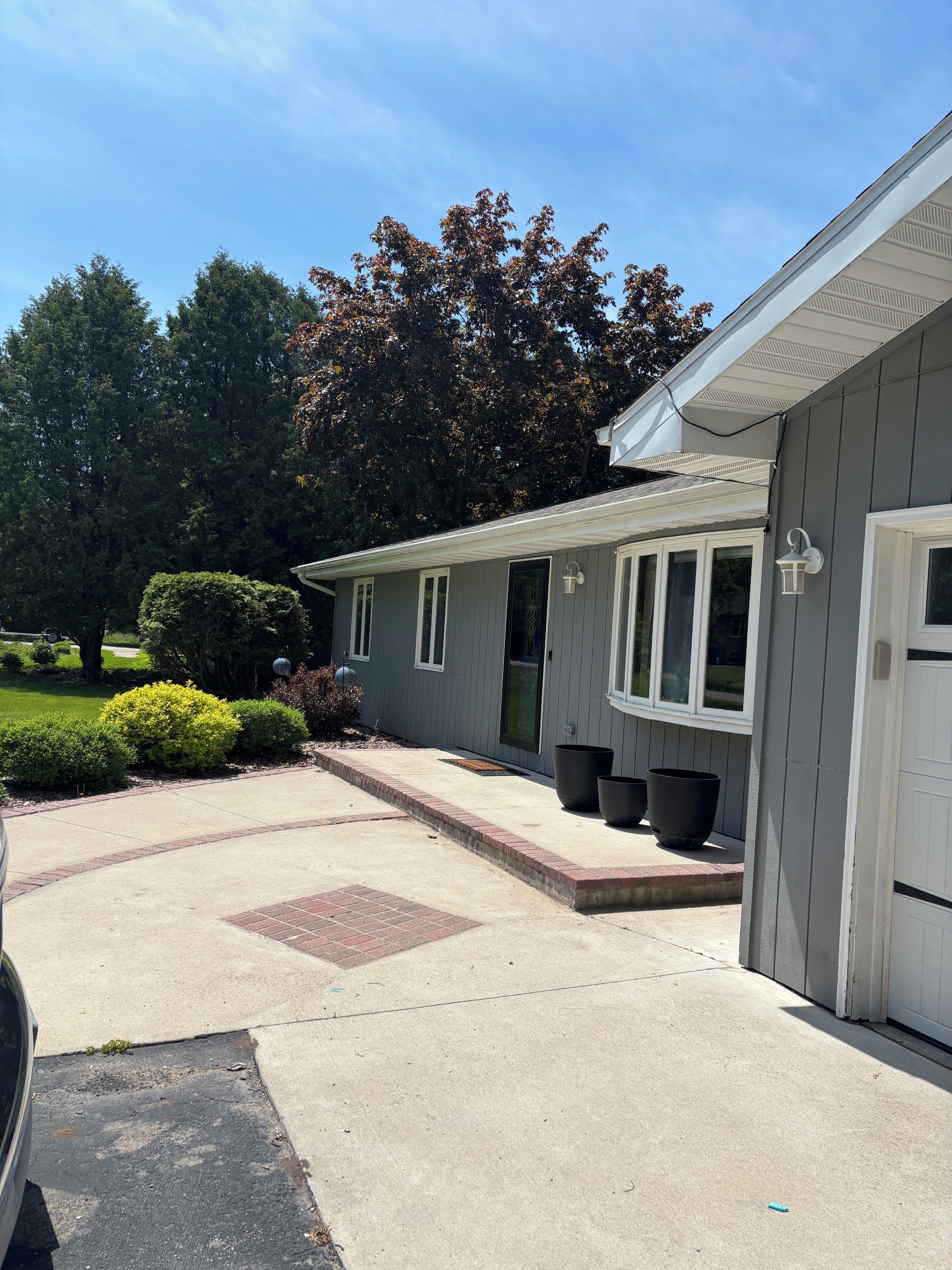 A residential house with a garage, a driveway, and a well-maintained lawn.