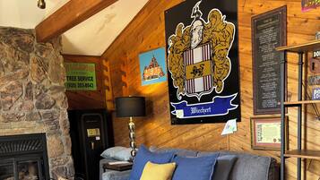 Een gezellige kamer met een bed, een stenen muur, een open haard en houten balken.
