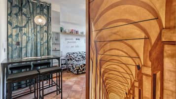 Una cucina moderna con zona pranzo, una tenda decorata e una frase motivazionale sulla parete.
