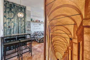 Una cucina moderna con zona pranzo, una tenda decorata e una frase motivazionale sulla parete.