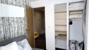 Quarto com cama, guarda-roupa e armário.