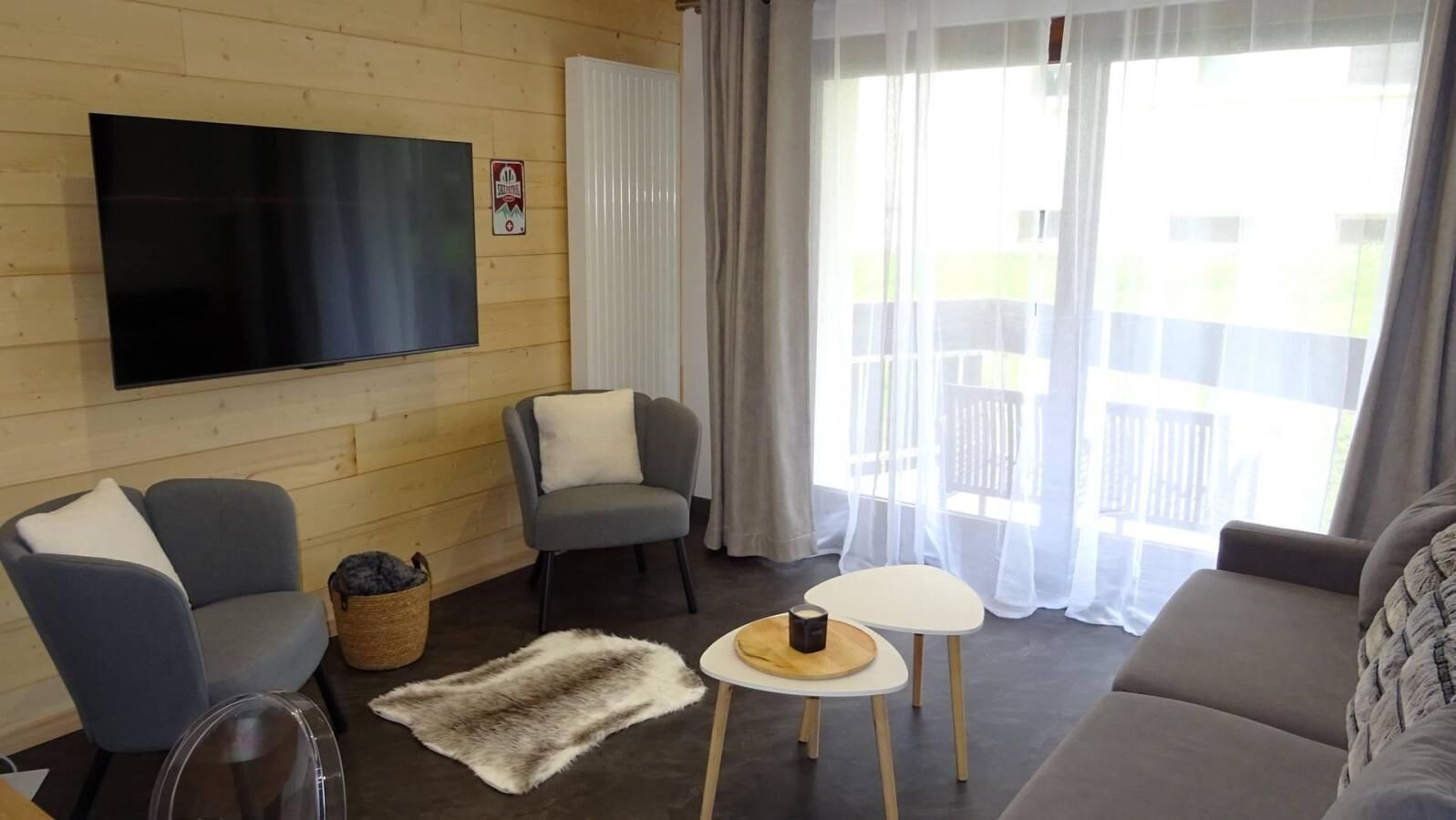 Un salon équipé d’un téléviseur à écran plat, de deux canapés, d’une petite table et d’un tapis.