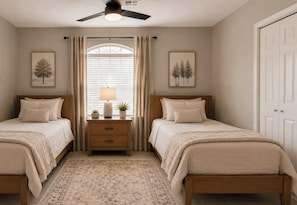 A bedroom with two beds, a nightstand with a lamp, and a window with curtains. - 4BR/2BA – Flexible Queen & Twin Sleeping – Quiet Neighborhood (Abilene)
