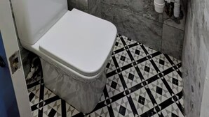 A small bathroom with a toilet, a sink, and marble tiles. - House Sleeps 5 With Parking and Garden (Feltham)