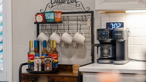 Een koffiebar met een Keurig koffiezetapparaat, theezakjes en een muggenhouder.