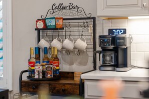 Una cafeteria amb una màquina de cafè Keurig, sobres de te i una pilona per a tasses.