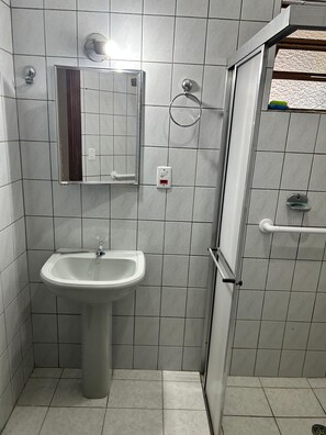 Ein Badezimmer mit Waschbecken, Spiegel und Dusche.