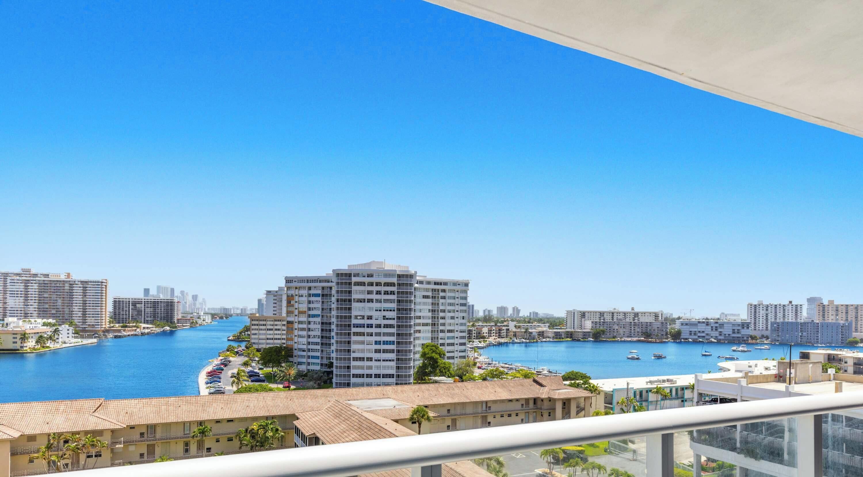 A high-rise building with a view of a marina and water.