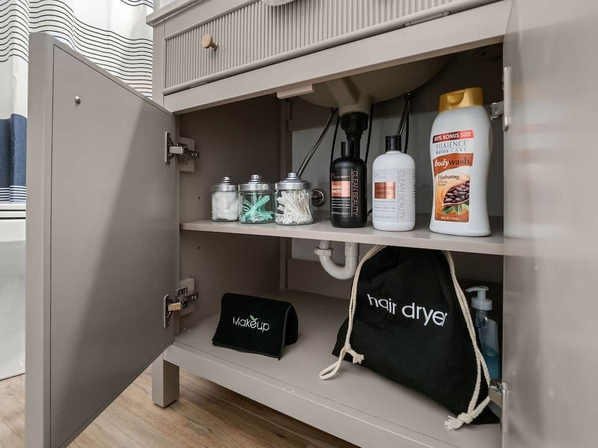 A bathroom cabinet with toiletries and a hair dryer.