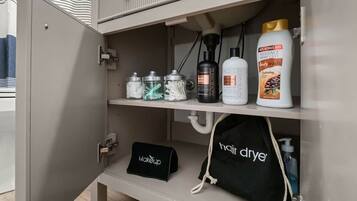 A bathroom cabinet with toiletries and a hair dryer.