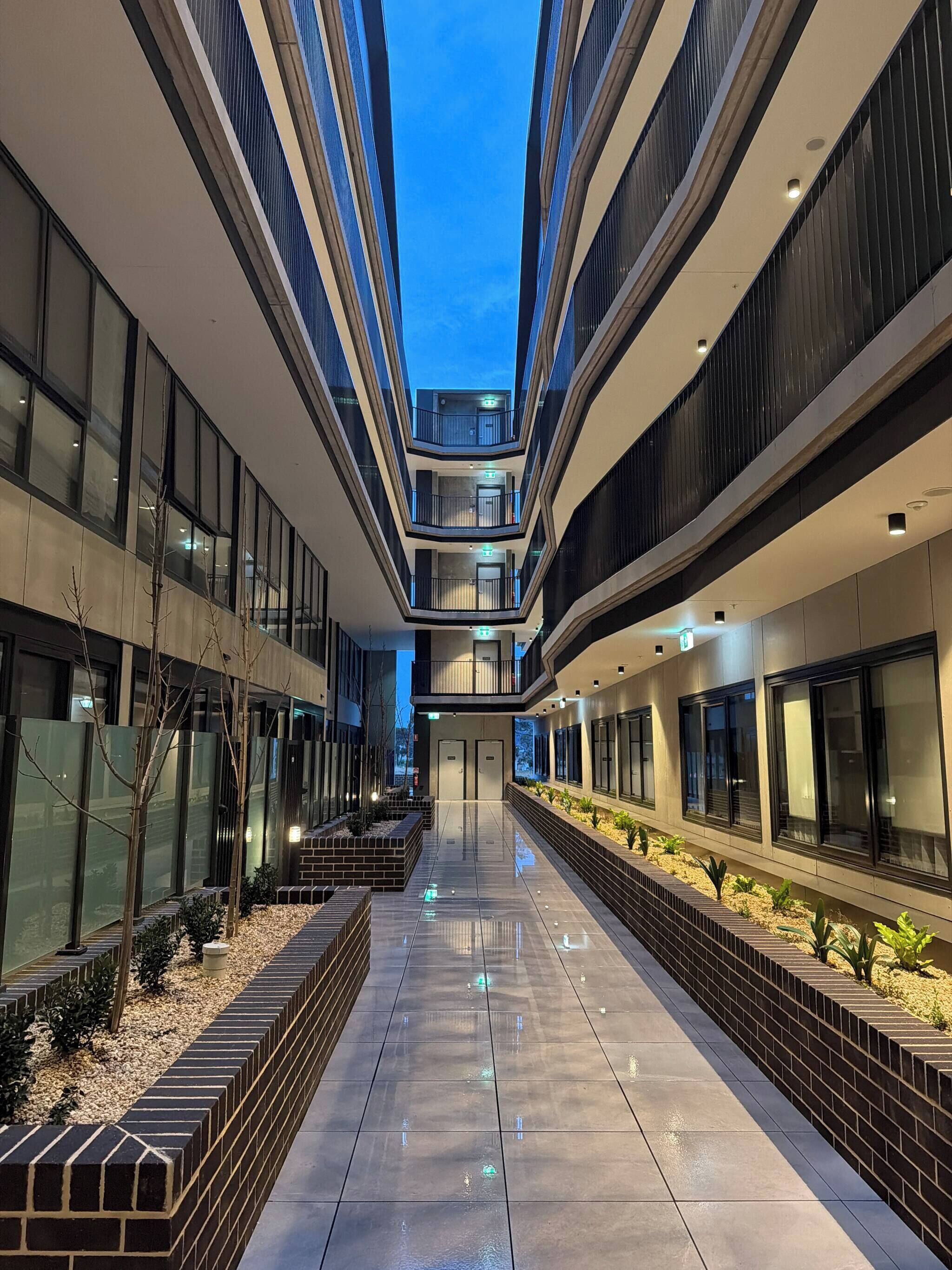 A modern building with multiple floors, a central atrium, and a reflective floor.