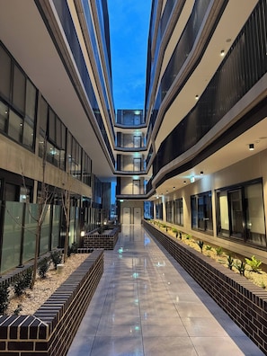 A modern building with multiple floors, a central atrium, and a reflective floor. - G6 Gungahlin Brand new (Canberra)
