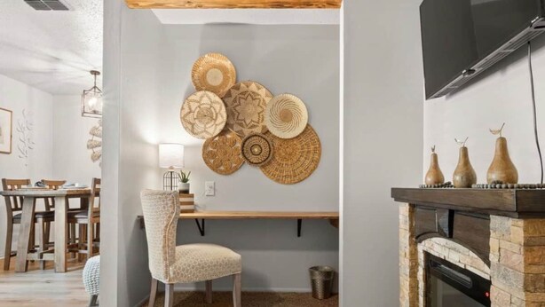 Sala de estar com lareira, espaço de jantar e parede decorada com cestos de palha.
