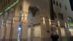 Entrada d'hotel amb un gran arc i una columna alta i ornamentada al primer pla.