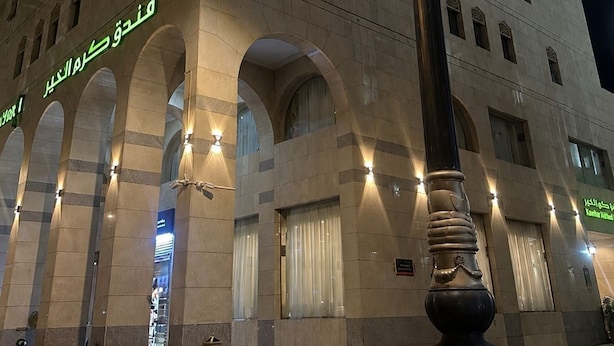 Entrada de hotel con un gran arco y una alta columna decorativa al frente.